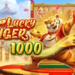Game cover for 'Lucky Tiger 1000' showing a roaring tiger mascot on a red pedestal with gold trim and a festive, sunlit backdrop.