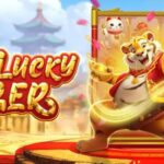 Promotional banner for the Lucky Tiger game showing a tiger hero on a gold stage with red carpet and gold coins surrounding the logo.